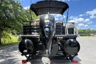 Slide: The Image of 2026 Ranger 223FC pontoon boat with canopy and powerful outboard motor, parked outdoors. - 1