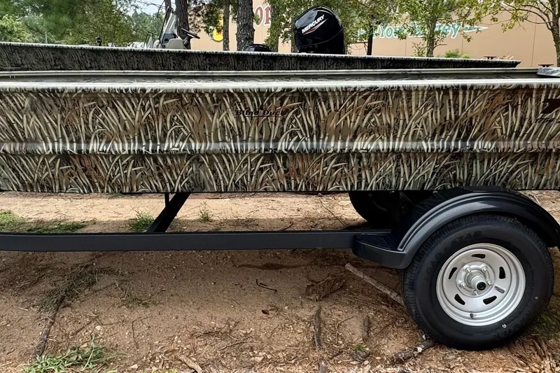 The Image of 2026 Tracker Grizzly 1754 Utility boat with camouflage design on a trailer. - 0