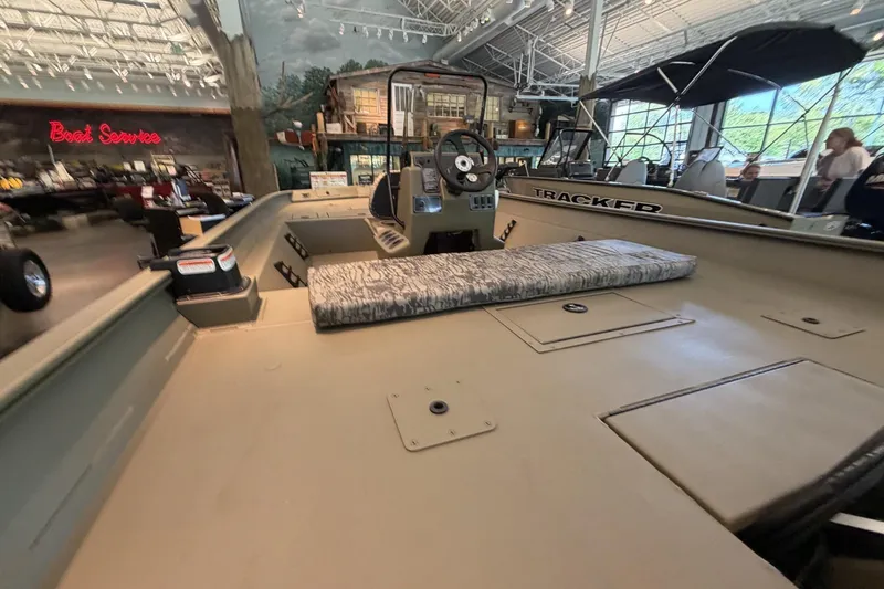 Slide: The Image of 2026 Tracker Grizzly 2072 CC boat interior in showroom, featuring steering console and seating. - 9
