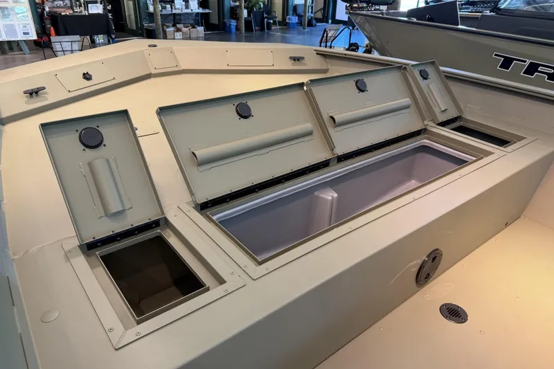 Slide: The Image of The image shows the deck of a Tracker Grizzly 2072 CC boat with multiple storage compartments. - 6
