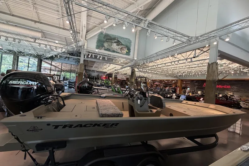 The Image of 2026 Tracker Grizzly 2072 CC boat displayed in a showroom with Mercury engine. - 0