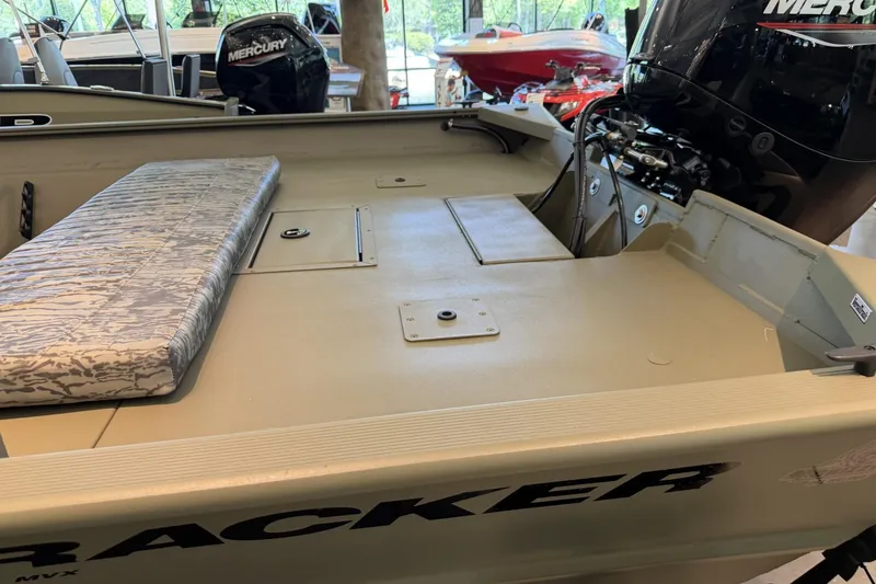 Slide: The Image of 2026 Tracker Grizzly 2072 CC boat interior with Mercury engine, featuring a cushioned bench seat. - 2