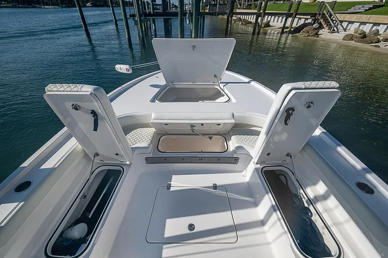 Slide: The Image of 2020 Caymas 28 HB boat deck with open storage compartments on calm water. - 8