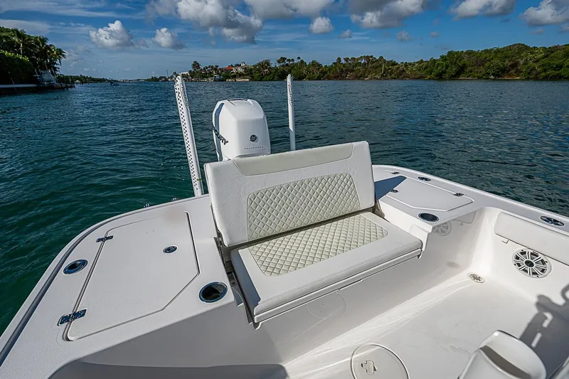 Slide: The Image of 2020 Caymas 28 HB boat with cushioned seating, on a scenic waterway. - 16