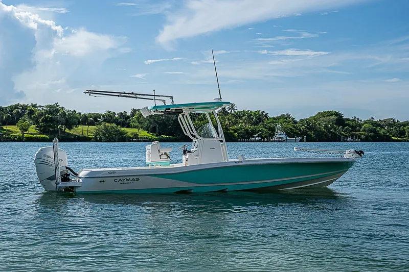 Slide: The Image of 2020 Caymas 28 HB boat on calm water with lush green shoreline. - 27