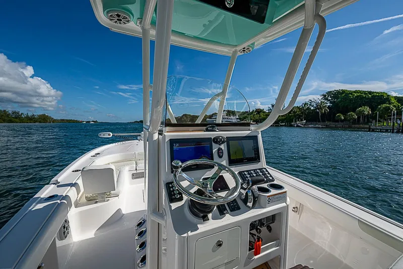 Slide: The Image of 2020 Caymas 28 HB boat helm with modern controls on a sunny day by the water. - 25