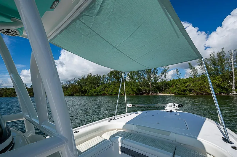 Slide: The Image of 2020 Caymas 28 HB boat with canopy, cruising on a scenic lake under blue skies. - 15