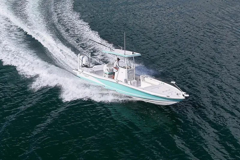 Slide: The Image of 2020 Caymas 28 HB boat cruising on open water, creating a wake. - 6