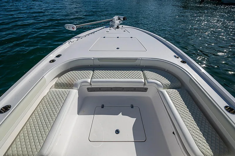 Slide: The Image of 2020 Caymas 28 HB boat deck with cushioned seating and storage, on calm water. - 11