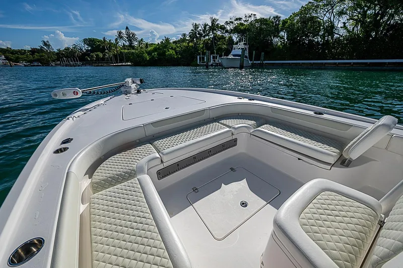 Slide: The Image of 2020 Caymas 28 HB boat interior with cushioned seating on a sunny day. - 10
