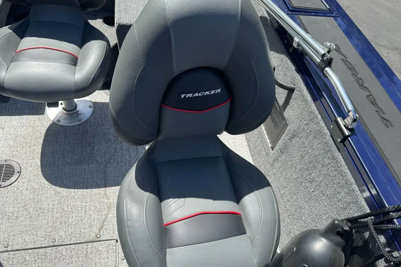 Slide: The Image of 2024 Tracker Targa V-18 Combo boat seats with gray upholstery and red accents. - 14
