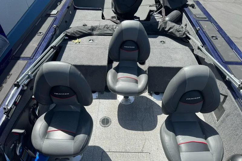 Slide: The Image of 2024 Tracker Targa V-18 Combo boat interior with three gray seats and carpeted flooring. - 15