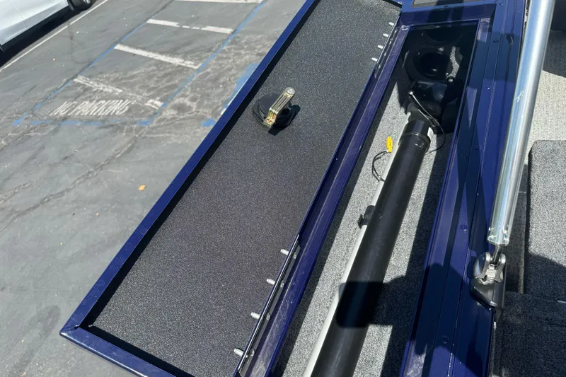 Slide: The Image of 2024 Tracker Targa V-18 Combo boat storage compartment with open lid, showcasing interior details. - 22