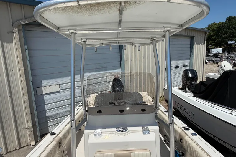 Slide: The Image of 2018 Carolina Skiff 22 Ultra Elite boat with T-top, parked near storage units. - 18