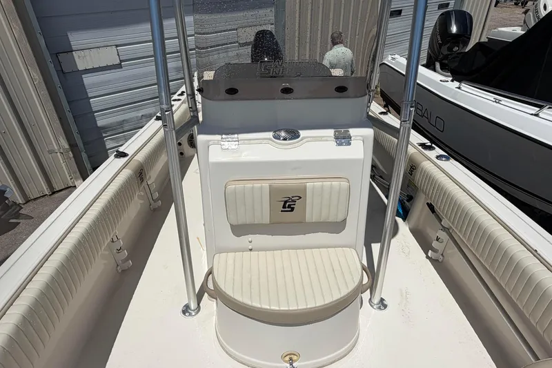 Slide: The Image of 2018 Carolina Skiff 22 Ultra Elite boat interior with seating and console, docked near other boats. - 19