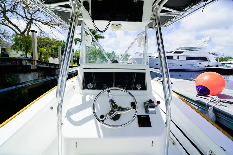 Slide: The Image of 1977 Scarborough 27 CC boat helm with steering wheel, docked near yachts. - 11