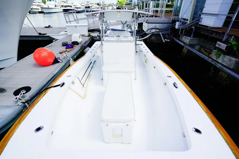 Slide: The Image of 1977 Scarborough 27 CC boat docked, featuring a clean white deck and seating area. - 19