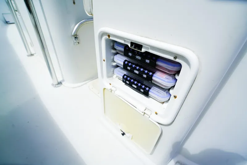 Slide: The Image of Storage compartment on a 1977 Scarborough 27 CC boat, containing organized tackle boxes. - 7
