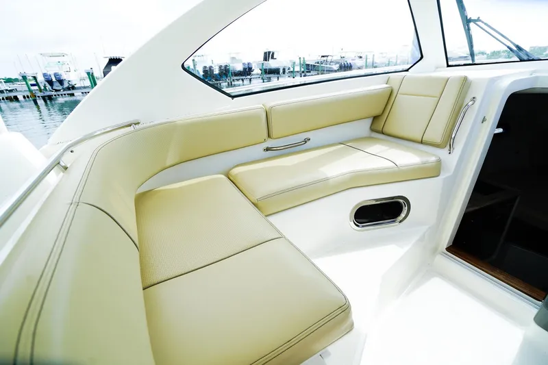 Slide: The Image of Luxurious seating area on a 2020 Pursuit OS 325 Offshore boat, docked at a marina. - 18