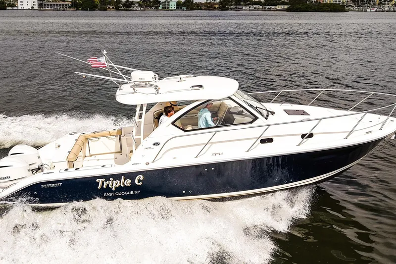 Slide: The Image of 2020 Pursuit OS 325 Offshore boat cruising on water, named "Triple C." - 2