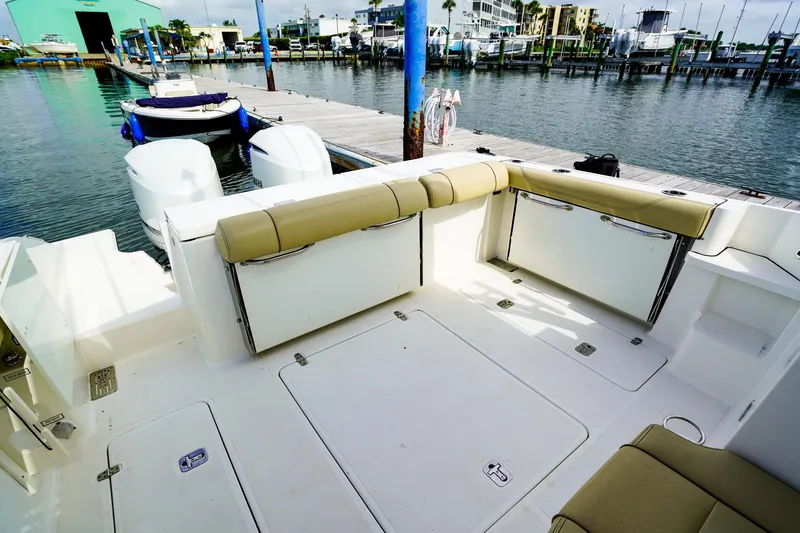 Slide: The Image of 2020 Pursuit OS 325 Offshore boat interior with seating and dock view. - 13