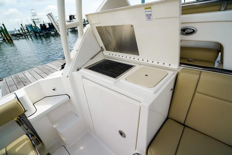 Slide: The Image of 2020 Pursuit OS 325 Offshore boat interior with seating and utility area by the dock. - 14