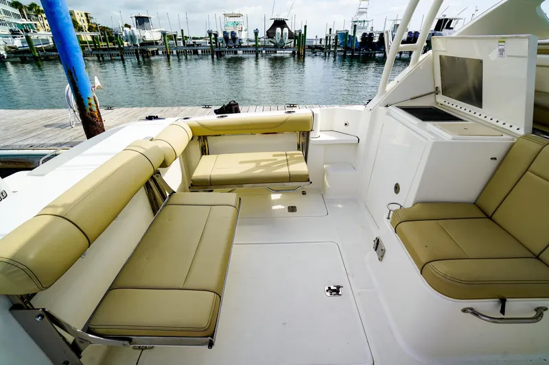 Slide: The Image of 2020 Pursuit OS 325 Offshore boat interior with beige seating, docked at marina. - 8