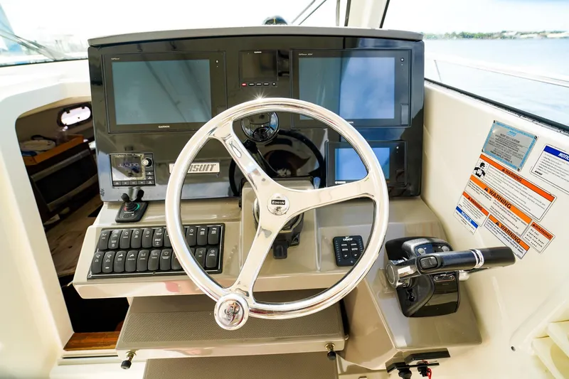 Slide: The Image of Helm of 2020 Pursuit OS 325 Offshore boat with modern controls and navigation screens. - 24