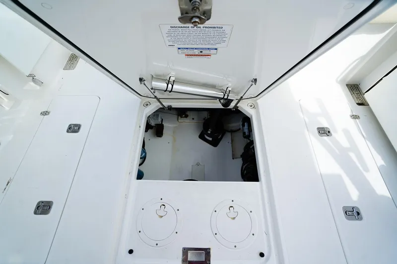Slide: The Image of Engine compartment of a 2020 Pursuit OS 325 Offshore boat, showcasing storage and access hatches. - 15