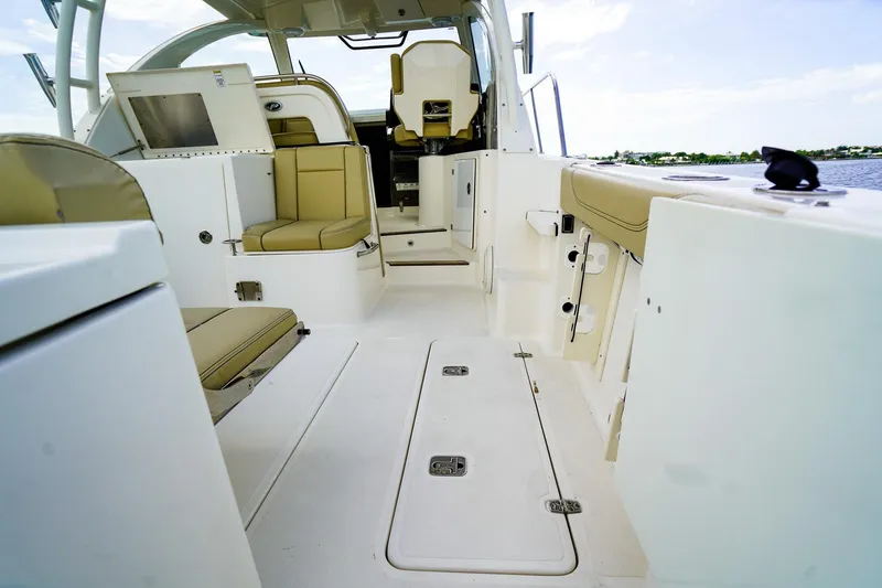 Slide: The Image of 2020 Pursuit OS 325 Offshore boat interior with beige seating and open deck layout. - 7