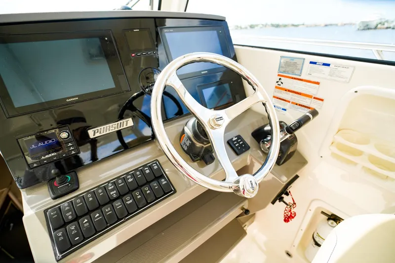 Slide: The Image of Helm of 2020 Pursuit OS 325 Offshore boat with modern controls and navigation displays. - 23