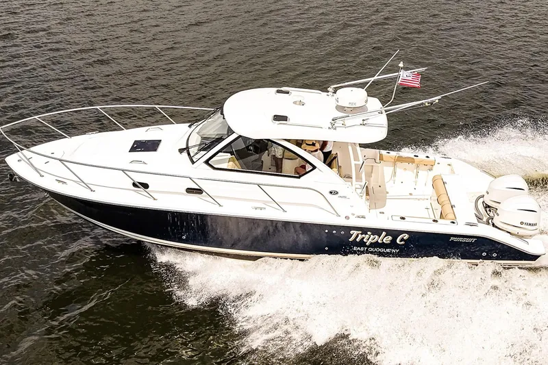 Slide: The Image of 2020 Pursuit OS 325 Offshore boat cruising on water with American flag. - 3
