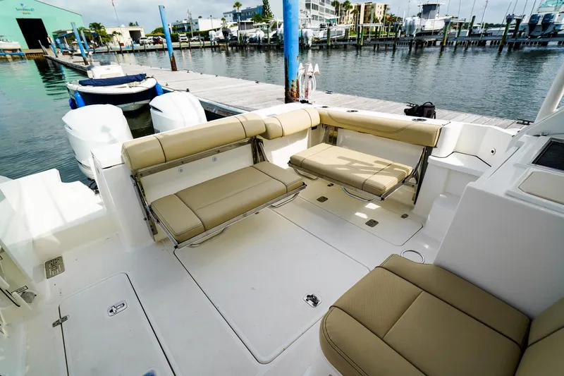 Slide: The Image of 2020 Pursuit OS 325 Offshore boat interior with beige seating at marina. - 9
