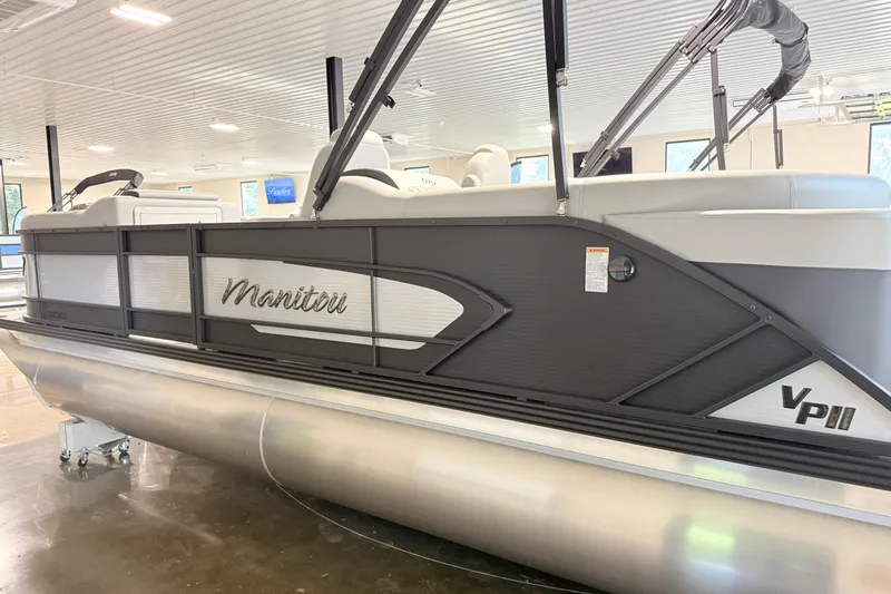 Slide: The Image of 2026 Manitou Encore SL SHP575 pontoon boat displayed indoors. - 2