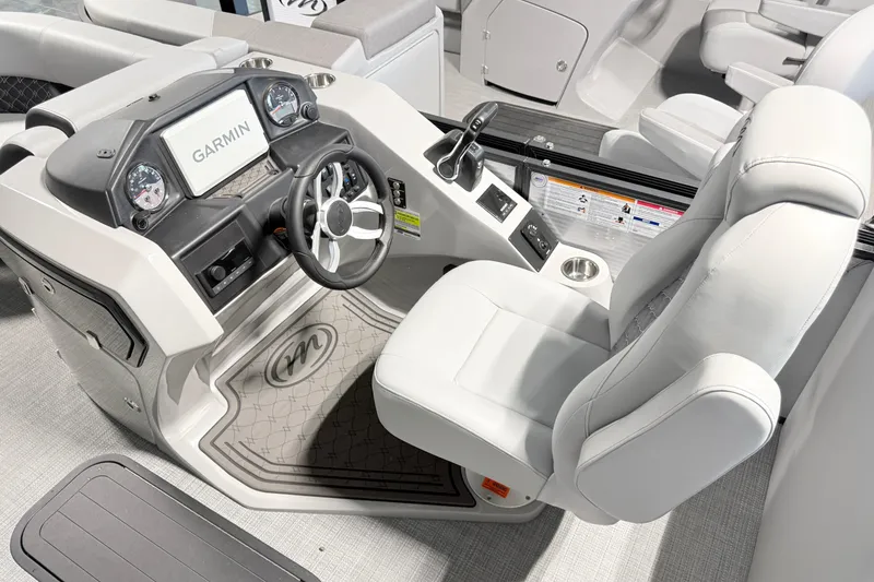 Slide: The Image of 2026 Manitou Encore SL SHP575 boat cockpit with Garmin display and luxurious seating. - 14