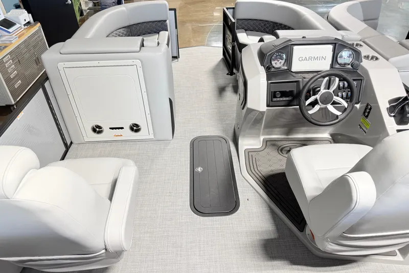 Slide: The Image of Interior of 2026 Manitou Encore Sl SHP575 boat with Garmin dashboard and plush seating. - 12