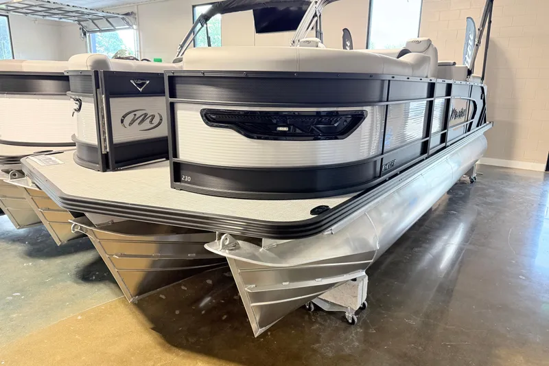 Slide: The Image of 2026 Manitou Encore SL SHP575 pontoon boat displayed indoors. - 3