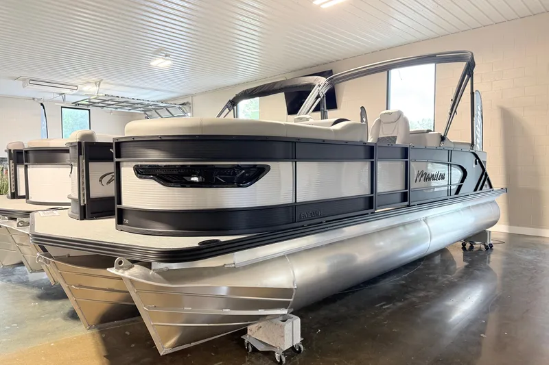The Image of 2026 Manitou Encore SL SHP575 pontoon boat in showroom, sleek design, modern features. - 0