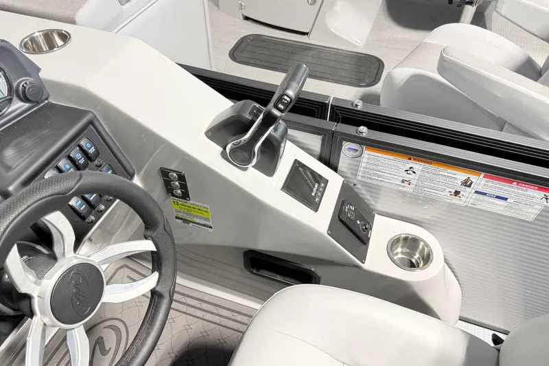 Slide: The Image of 2026 Manitou Encore SL SHP575 boat dashboard with steering wheel and controls. - 16