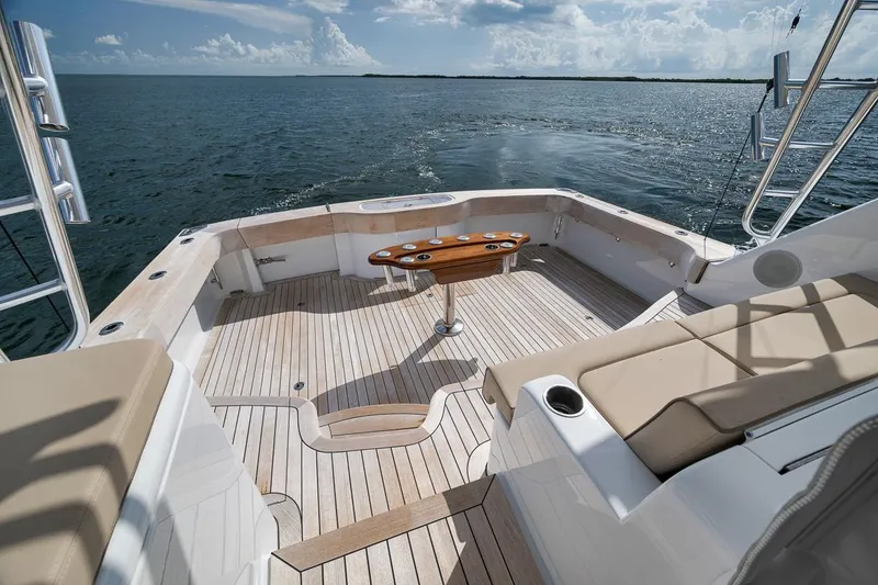 Slide: The Image of 2023 Hatteras GT45X Tower yacht deck with seating, table, and ocean view. - 23