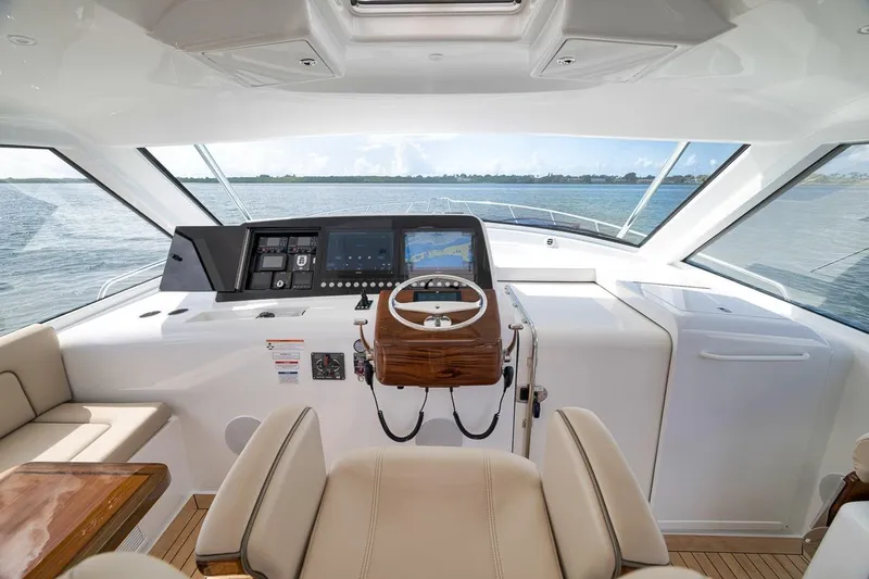 Slide: The Image of 2023 Hatteras GT45X Tower yacht helm with modern controls and panoramic water view. - 33