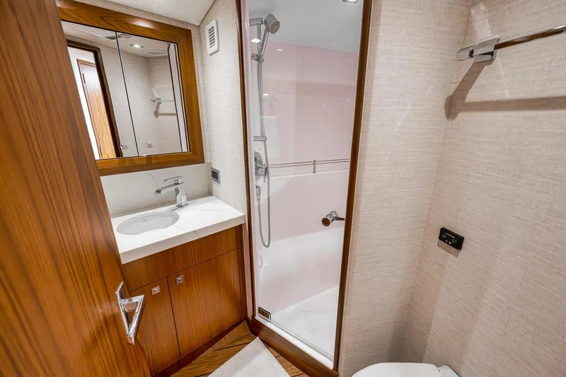 Slide: The Image of Luxurious bathroom interior of 2023 Hatteras GT45X Tower yacht, featuring modern fixtures and wood accents. - 44