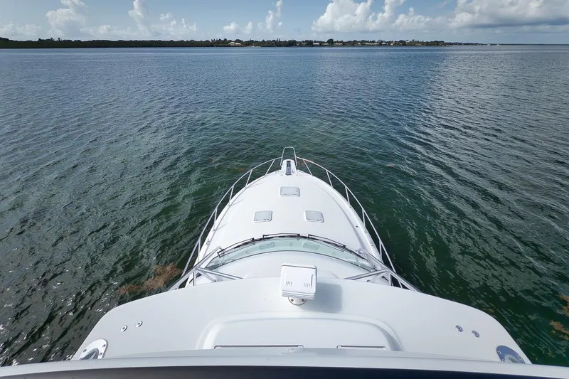 Slide: The Image of Bow view of 2023 Hatteras GT45X Tower yacht on calm waters. - 11