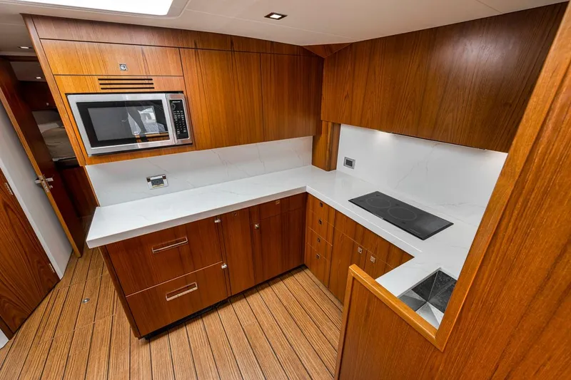 Slide: The Image of Luxurious kitchen interior of 2023 Hatteras GT45X Tower yacht with wood cabinetry and modern appliances. - 37