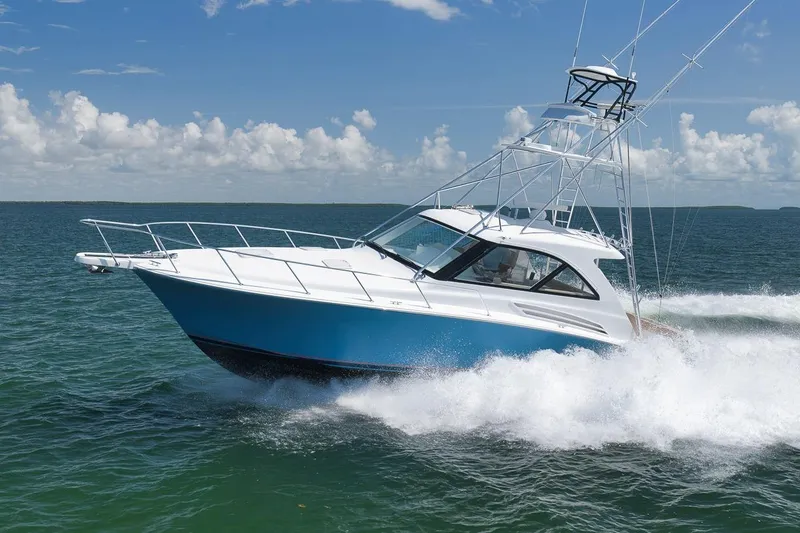 Slide: The Image of 2023 Hatteras GT45X Tower yacht cruising on open water under a clear sky. - 4