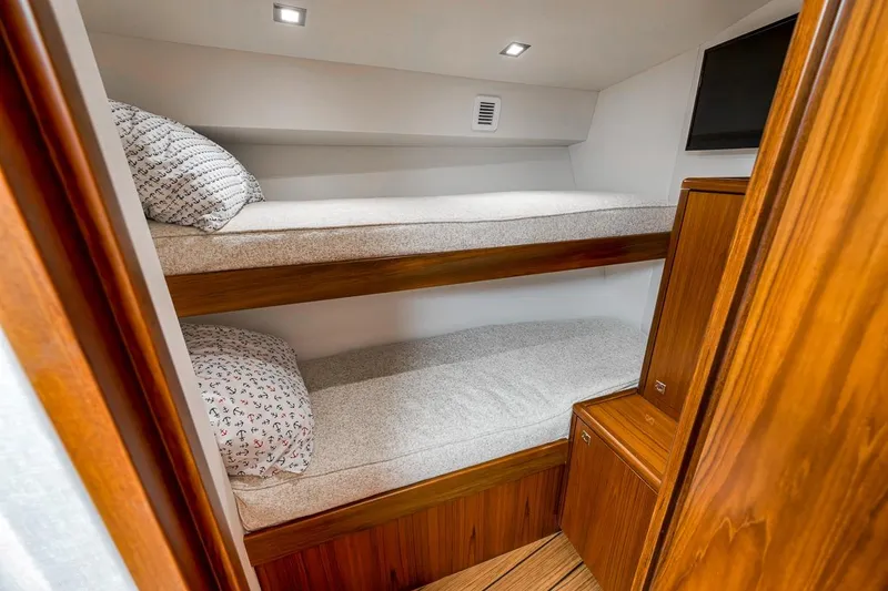 Slide: The Image of 2023 Hatteras GT45X Tower cabin with wooden bunk beds and modern lighting. - 43