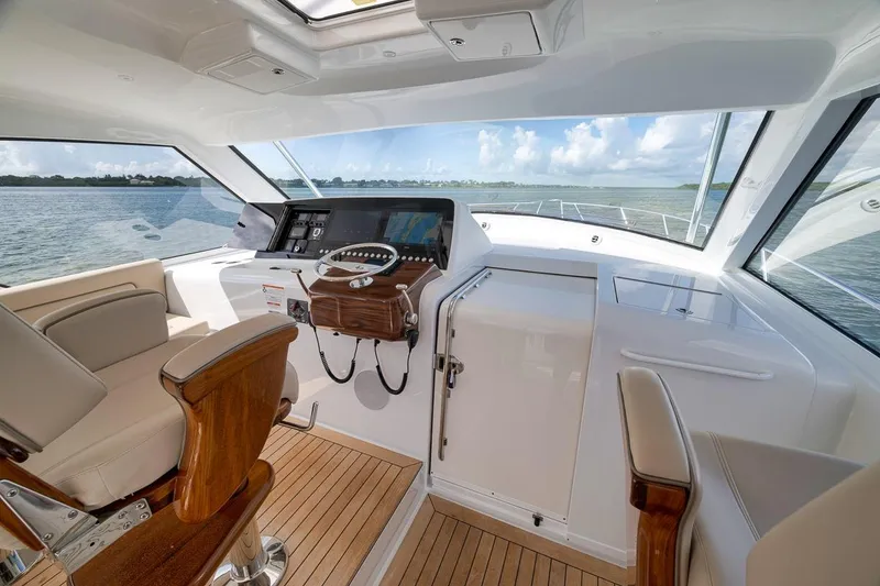 Slide: The Image of 2023 Hatteras GT45X Tower yacht interior with helm, luxurious seating, and panoramic windows. - 34