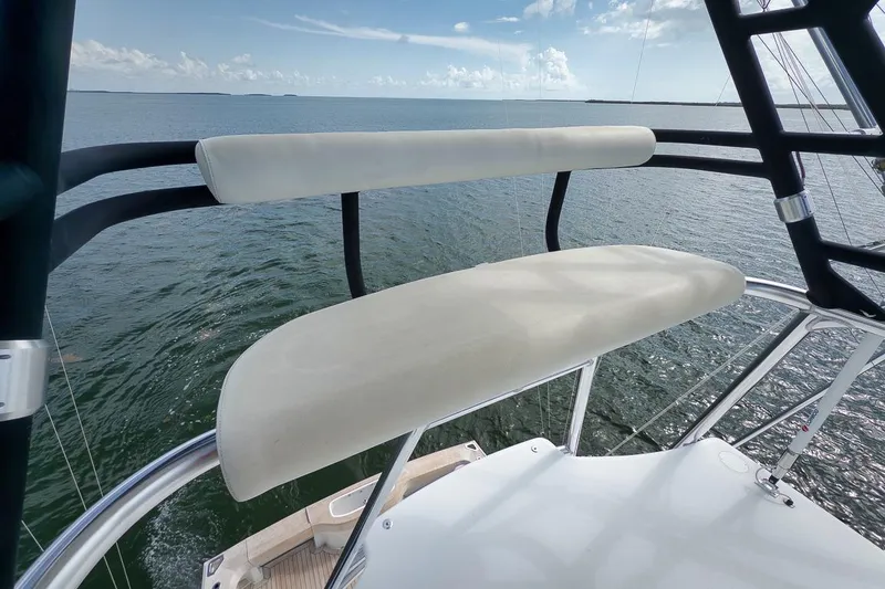 Slide: The Image of 2023 Hatteras GT45X Tower boat with elevated seating, overlooking serene waters. - 10