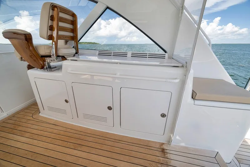 Slide: The Image of 2023 Hatteras GT45X Tower yacht interior with wooden flooring and seating, overlooking the ocean. - 25
