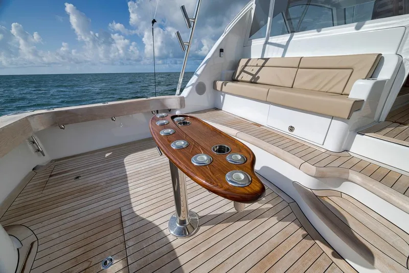 Slide: The Image of 2023 Hatteras GT45X Tower yacht deck with seating and wooden table, ocean view. - 13